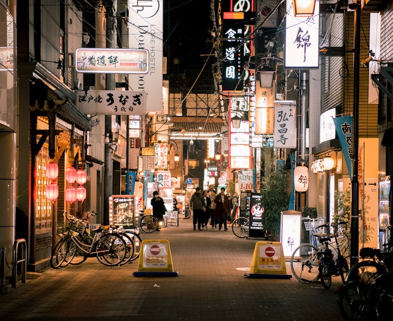 Bustling evening scene of Osaka's vibrant shopping street with illuminated signs and people walking.