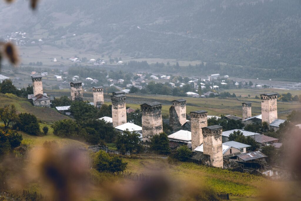 Aerial view of iconic medieval towers and village in foggy Svaneti, Georgia.