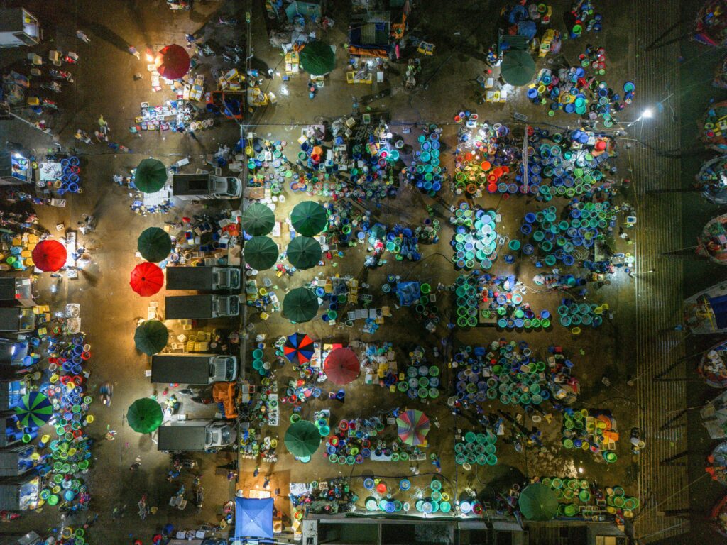 Bustling night market in Hạ Long, Vietnam, captured from above, showcasing vibrant stalls and activity.