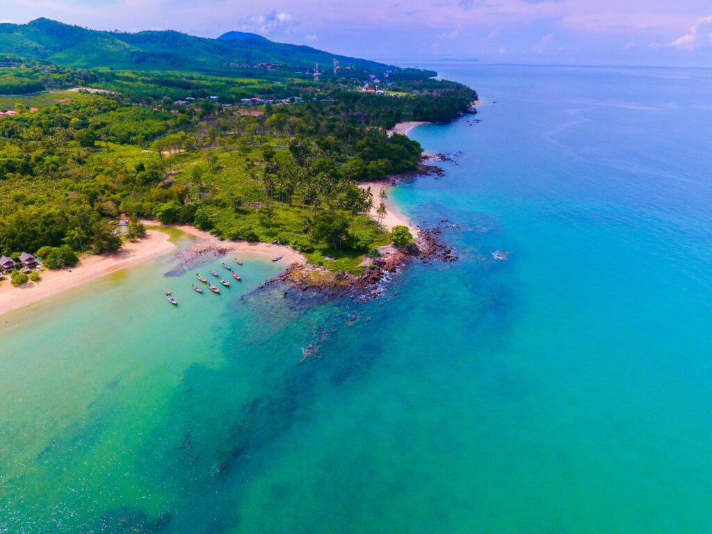 Stunning aerial view of a tropical beach and lush green landscape in Koh Lanta, Thailand.