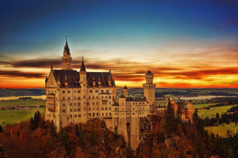 Breathtaking view of Neuschwanstein Castle in Germany during a vibrant sunset scene.